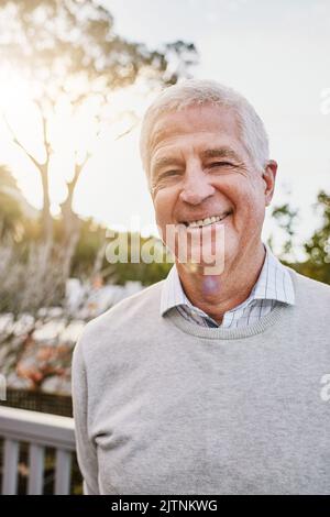 Es gibt eine Menge zu lächeln. Porträt eines glücklichen älteren Mannes, der draußen steht. Stockfoto