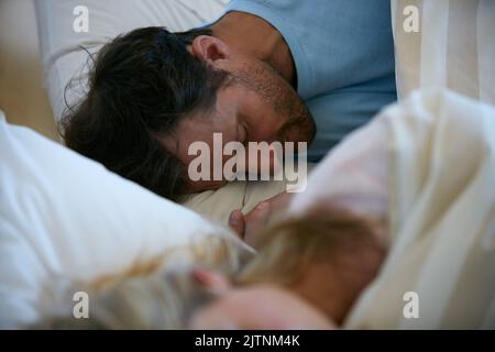 Geben Sie nie Ihre Träume auf, schlafen Sie weiter. Ein junges Paar schläft schnell im Bett. Stockfoto