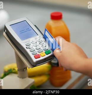 Bereit für Transaktion. Nahaufnahme einer Kreditkartenzahlung in einem Lebensmittelgeschäft. Stockfoto