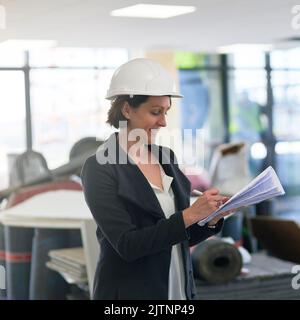 Ich liebe es, wenn ein Plan zusammenkommt. Eine Baumanagerin auf der Baustelle, die einen Hardhut trägt. Stockfoto