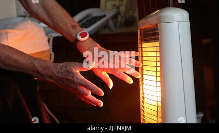 Aktenfoto vom 19/11/14 einer älteren Dame mit Elektrofeuer zu Hause in Liverpool. Experten haben gewarnt, dass eine „erhebliche humanitäre Krise mit Millionen von Kindern in Mitleitern der Entwicklung“ auf dem Weg ist, wenn die Regierung nicht tut, um zu verhindern, dass mehr als die Hälfte der britischen Haushalte in die Kraftstoffarmut einstürzt. Ausgabedatum: Donnerstag, 1. September 2022. Stockfoto