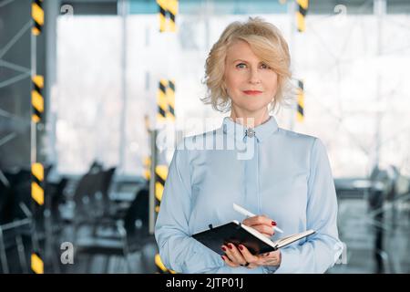 Gealterte Geschäftsfrau schreibt Tagebuch Planung Coaching Stockfoto