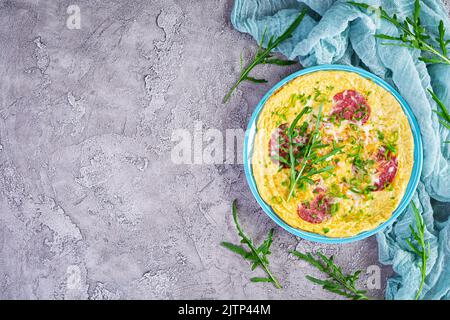 Omelette mit Wurst, Kräutern und geriebenem Käse. Einfaches Frühstück. Draufsicht Stockfoto