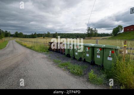 Die Mülltonnen befinden sich entlang der Landstraße. Stockfoto