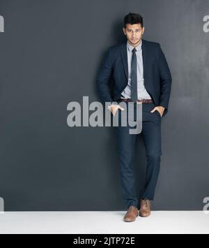 Der Erfolg liegt bei Ihnen. Studioaufnahme eines jungen Geschäftsmannes, der mit den Händen in den Taschen vor einem grauen Hintergrund steht. Stockfoto