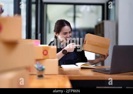 Junge Start-up-Geschäft Frau Asian arbeiten als KMU-Unternehmer neues Unternehmen mit Verpackung Box, Vorbereitung für senden an Kunden. Stockfoto