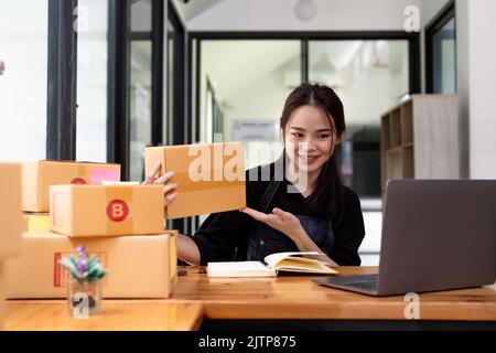 Junge Start-up-Geschäft Frau Asian arbeiten als KMU-Unternehmer neues Unternehmen mit Verpackung Box, Vorbereitung für senden an Kunden. Stockfoto