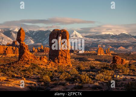 Balanced Rock im Arches National Park in der Nähe von Moab, Utah. Im Hintergrund befinden sich die schneebedeckten La Sal Mountains. Stockfoto