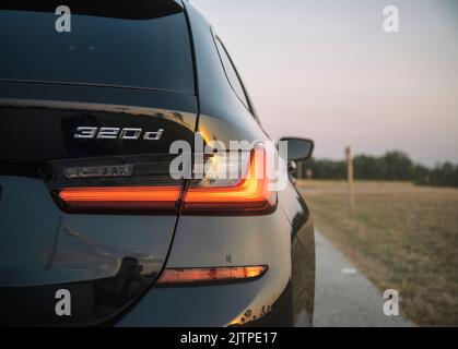 BMW 320d Logo auf dunkler Rückleuchte. Hochwertige Fotos Stockfoto