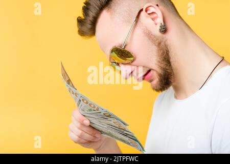 Erfolgreiche Millennial verwirrt Kerl Porträt Geld Stockfoto