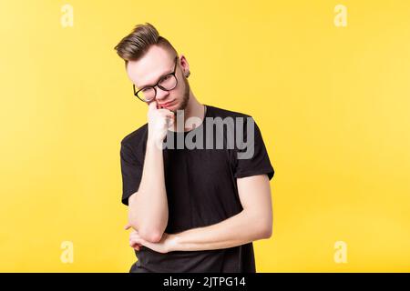 Junger Mann misstrauisch vorsichtig gelangweilt Blick Skepsis Stockfoto