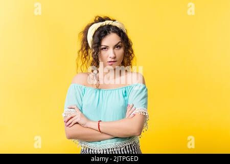 Junge Frau starren Blick kreuzte die Arme skeptisch Stockfoto