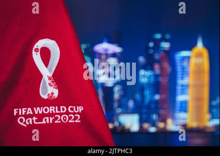 DOHA, KATAR, 30. AUGUST 2022: Logo der FIFA Fußball-Weltmeisterschaft Katar 2022 und nächtliche Skyline von Doha im Hintergrund. Fußball WM Katar 2022 Tapete und bla Stockfoto