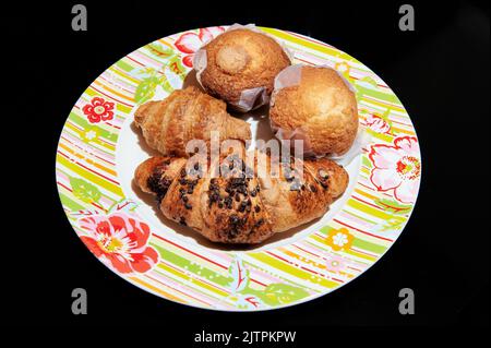 Teller mit Schokoladencroissants und Muffins zum Frühstück Stockfoto