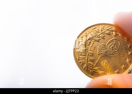 Türkischen osmanischen Stil Gold Münze in der Hand auf weißem Hintergrund Stockfoto