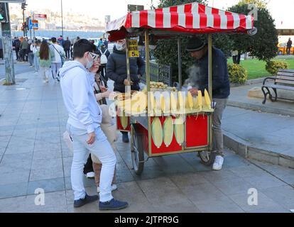 ISTANBUL, TÜRKEI-OKTOBER 30: Nicht identifizierte Kunden kaufen Mais in der Nähe des Bahnhofs Sirkeci. Oktober 30,2021 in Istanbul, Türkei Stockfoto