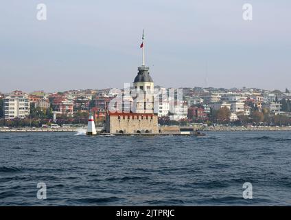 ISTANBUL, TÜRKEI-NOV 02: Maiden's Tower alias kiz Kulesi mit Gebäuden von Uskudar Hintergrund einer Fähre. November 02,2021 in Istanbul, Türkei Stockfoto