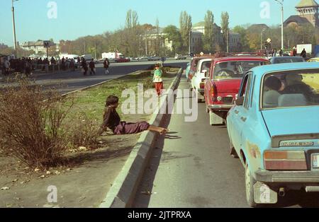 Bukarest, Rumänien, 1990. Junger Mann mit schwerer Behinderung bettelt auf der Straße. Stockfoto