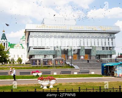 Yoshkar-Ola, Russland - 24. August 2022: Vogelschar und Bau des Akademischen Russischen Schauspieltheaters, benannt nach Georgy Konstantinov auf dem Nikonov-Platz Stockfoto