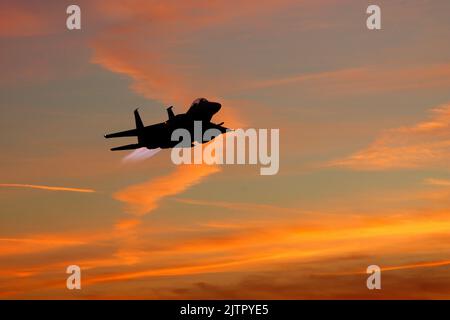 Ein US Air Force McDonnell Douglas F-15E Strike Eagle startet bei Sonnenuntergang von RAF Lakenheath, Suffolk. Stockfoto