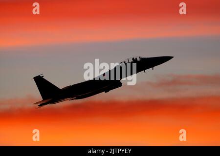 Ein US Air Force McDonnell Douglas F-15E Strike Eagle startet bei Sonnenuntergang von RAF Lakenheath, Suffolk. Stockfoto