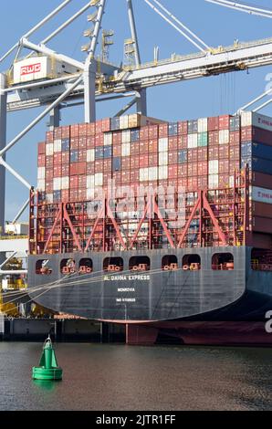 Rotterdam, Niederlande, 23. August 2022: stern eines Containerschiffes mit schwarzem Rumpf, beladen mit Containern und mit einem großen Kran auf dem Kai Stockfoto