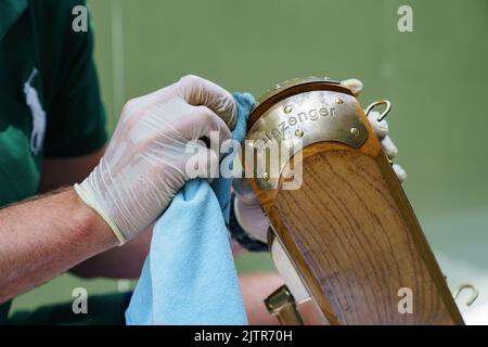 Der Platzwart poliert einen Nettoposten bei den Meisterschaften 2022. Im All England Lawn Tennis Club, Wimbledon Stockfoto