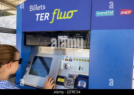 Wingen sur Moder, Frankreich - 08. August 2022 : Junge Mädchen, die ein Ticket kauft, bevor sie ihren Zug in einem SNCF-Bahnhof nimmt Stockfoto