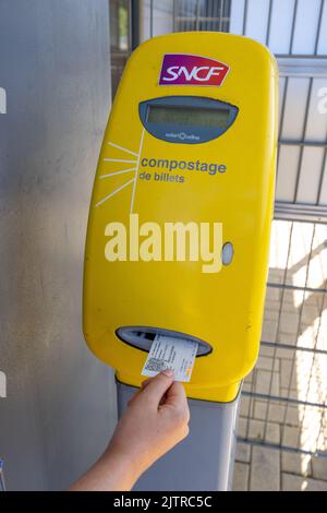 Wingen sur Moder, Frankreich - 08. August 2022 : Mädchen, die vor der Fahrt mit dem Zug in einem SNCF-Bahnhof ein Ticket angemeldet hat. Stockfoto