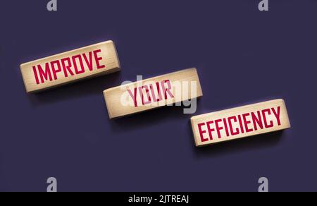 Geschäftskonzept. Auf einer violetten Oberfläche, Holzblöcke mit der Aufschrift - STEIGERN SIE IHRE EFFIZIENZ Stockfoto