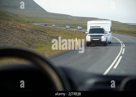 Island, Sudurland - August 8., 2022 - Auto schleppen einen Anhänger auf einer Straße. Stockfoto