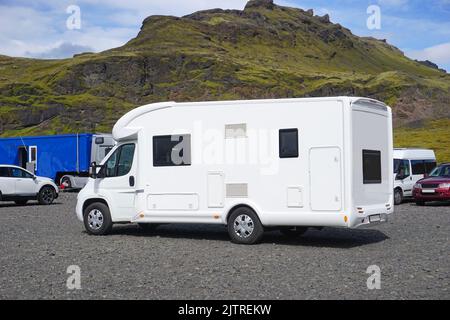 Island, Sudurland - 8.. August 2022 - Weißer Camper auf dem Parkplatz - Seitenansicht. Stockfoto