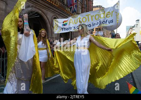 Manchester Pride Parade. AutoTrader Parade vor dem Midland Hotel. Frau in Gold und Weiß Kostüm. Themenmarsch für den Frieden Stockfoto