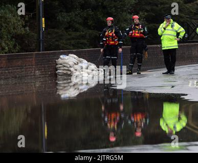 RETTUNGSDIENSTE BEHALTEN IM AUGE NDIE SANDSÄCKE, DIE EINEN RISS IN DER WAND BEDECKEN, WÄHREND DER FLUSS WALLINGTON DROHT, SEINE UFER ZU SPRENGEN UND DAS DORF WALLINGTON IN DER NÄHE VON FAREHAM, HANTS, ZU ÜBERFLUTEN. BILDER VON MIKE WALKER, MIKE WALKER, 2012 Stockfoto