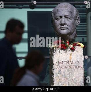 Berlin, Deutschland. 01. September 2022. Vor dem Verlag Axel Springer, in dem unbekannte Menschen Blumen gelegt haben, blickt man auf eine Büste von Michail Gorbatschow. Der Friedensnobelpreisträger und ehemalige sowjetische Führer Michail Gorbatschow ist im Alter von 91 Jahren gestorben. Er galt als einer der Väter der deutschen Einheit und als Wegbereiter für das Ende des Kalten Krieges. Quelle: Wolfgang Kumm/dpa/Alamy Live News Stockfoto