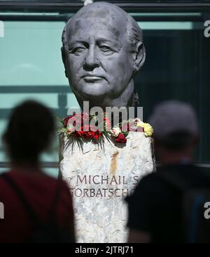 Berlin, Deutschland. 01. September 2022. Vor dem Verlag Axel Springer, in dem unbekannte Menschen Blumen gelegt haben, blickt man auf eine Büste von Michail Gorbatschow. Der Friedensnobelpreisträger und ehemalige sowjetische Führer Michail Gorbatschow ist im Alter von 91 Jahren gestorben. Er galt als einer der Väter der deutschen Einheit und als Wegbereiter für das Ende des Kalten Krieges. Quelle: Wolfgang Kumm/dpa/Alamy Live News Stockfoto
