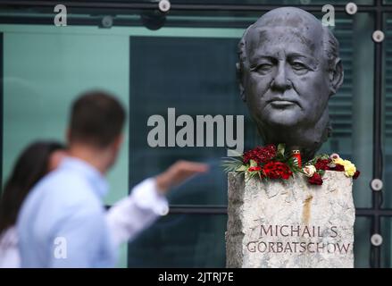 Berlin, Deutschland. 01. September 2022. Vor dem Verlag Axel Springer, in dem unbekannte Menschen Blumen gelegt haben, blickt man auf eine Büste von Michail Gorbatschow. Der Friedensnobelpreisträger und ehemalige sowjetische Führer Michail Gorbatschow ist im Alter von 91 Jahren gestorben. Er galt als einer der Väter der deutschen Einheit und als Wegbereiter für das Ende des Kalten Krieges. Quelle: Wolfgang Kumm/dpa/Alamy Live News Stockfoto