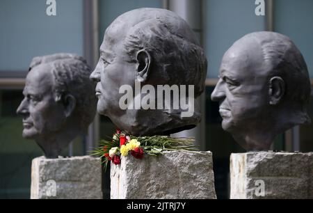 Berlin, Deutschland. 01. September 2022. Die Büsten von US-Präsident George Bush (l-r), dem russischen Präsidenten Michael Gorbatschow und dem deutschen Bundeskanzler Helmut Kohl stehen vor dem Axel Springer Verlagsgebäude. Die Büste von Michael Gorbatschow ist mit Blumen geschmückt. Der Friedensnobelpreisträger und ehemalige sowjetische Führer Michail Gorbatschow ist im Alter von 91 Jahren gestorben. Er galt als einer der Väter der deutschen Einheit und als Wegbereiter für das Ende des Kalten Krieges. Quelle: Wolfgang Kumm/dpa/Alamy Live News Stockfoto