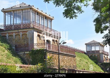 Der Stausee Montsouris, Paris. Die beiden eleganten Jugendstil-Pavillons, die Wasser aus unterirdischen Aquädukten in den Stausee ablassen. Stockfoto