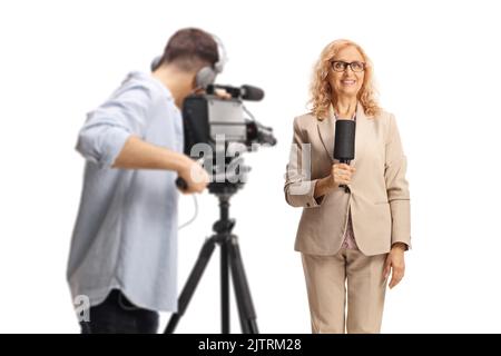 Kameramann, der eine Reporterin mit einem isolierten Mikrofon aufzeichnet Weißer Hintergrund Stockfoto