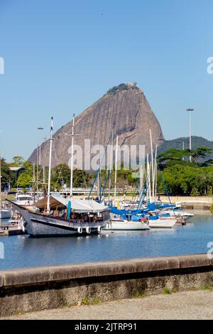 Boote, die in Gloria Marina mit dem zuckerhut im Hintergrund in Rio de Janeiro, Brasilien, festgemacht sind - 22. Juni 2020: Gloria Manrina mit dem zuckerhut im Stockfoto