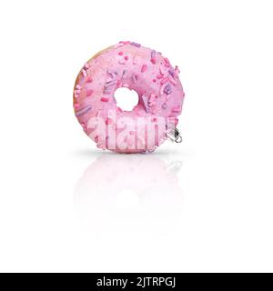 Frischer rosa glasierte Donut als Weihnachtsdekoration auf weißem Hintergrund mit Reflexion. Kreatives Bild mit leckeren schönen Gebäck als Weihnachtsbaum Spielzeug. Quadratisch Stockfoto