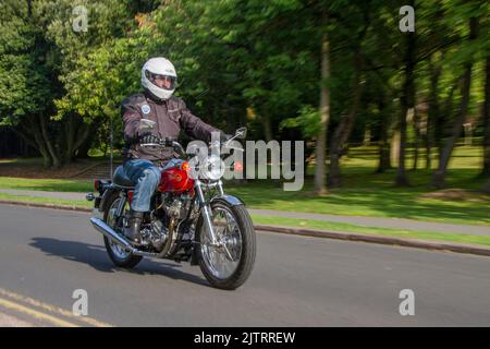 1975 70s Red Norton 828cc Commando; Motorradfahrer. Oldtimer-Motorrad bei der jährlichen Stanley Park Classic Bike Show. Die Stanley Park Classics Yesteryear Motor Show wird von der Blackpool Vintage Vehicle Preservation Group, Großbritannien, veranstaltet. Stockfoto