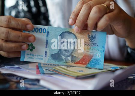 Halten von Rupiah-Banknoten Stockfoto