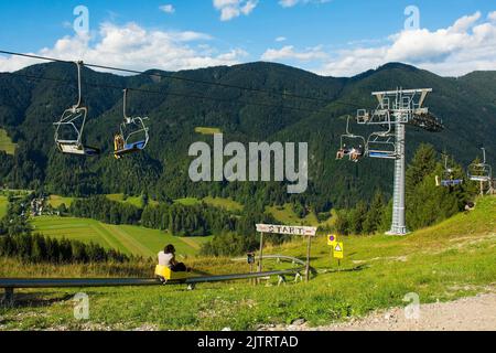 Kranjska Gora, Slowenien - August 21. 2022. Touristen genießen eine Skilift-Fahrt auf den Gipfel eines Hügels und dann Rodeln zurück nach Kranjska Gora Stockfoto