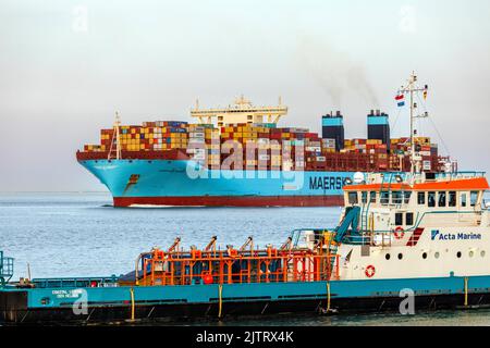 Nordsee an der Mündung der Elbe am Abend, Containerschiff Marchen Maersk, im Vordergrund das Offshore-Versorgungsschiff Coastal Legend Stockfoto