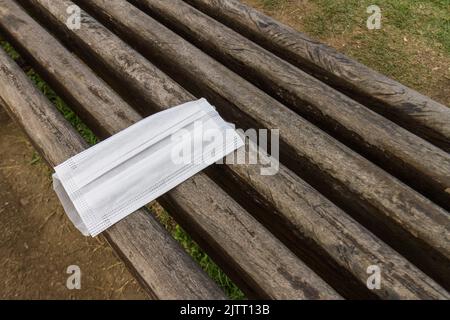 Schutzmaske, die unregelmäßig über einer öffentlichen Bank in rio de janeiro, brasilien, abgelegt wird. Stockfoto