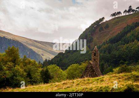 Steindach und runder Glockenturm von St. Kevins Küche in Glendalough, Irland. Stockfoto