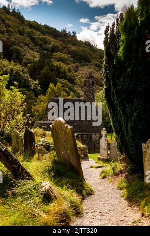 Steindach und runder Glockenturm von St. Kevins Küche in Glendalough, Irland. Stockfoto