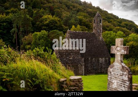 Steindach und runder Turm der St. Kevins Küche in Glendalough, Irland. Stockfoto